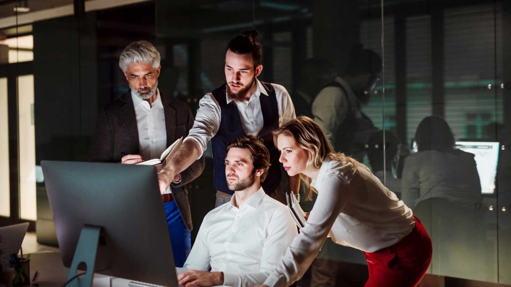 A group of business people in an office at night